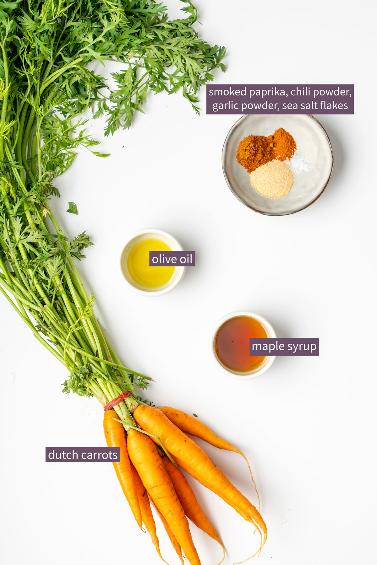Vibrant ingredients for maple roasted carrots on a white surface