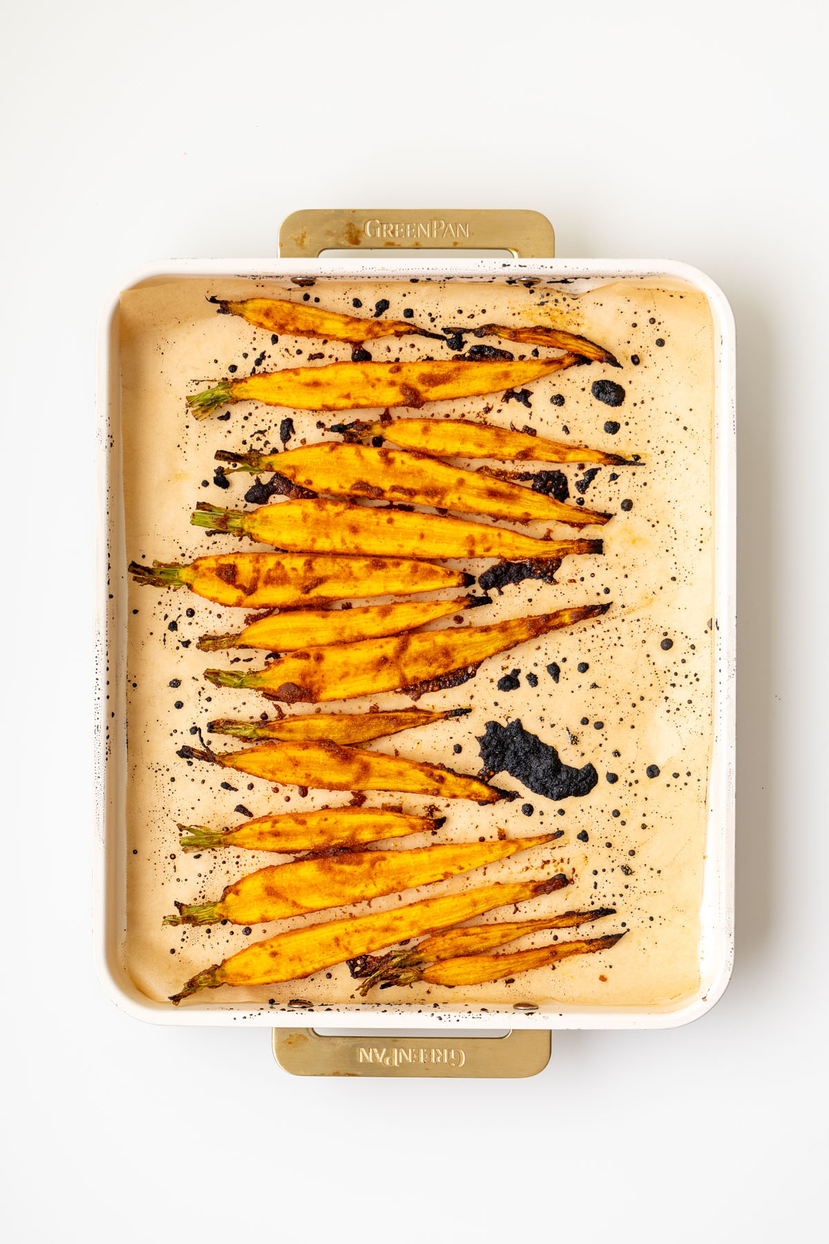 Maple roasted dutch carrots caramelized on a parchment-lined baking tray