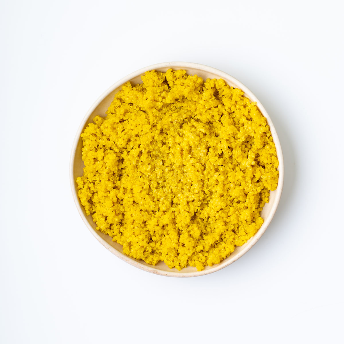 Turmeric quinoa and edamame salad served fresh with mint, avocado, and a drizzle of satay dressing