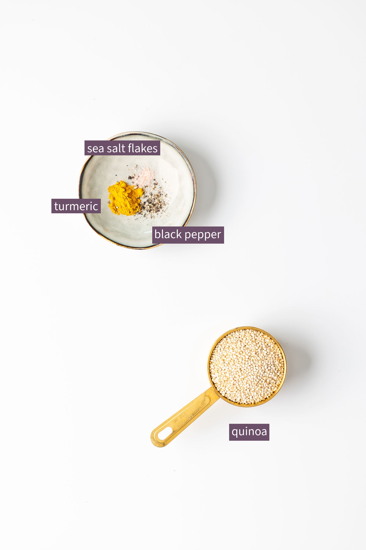 Colorful turmeric quinoa and edamame salad topped with diced avocado, chopped walnuts, and scallions