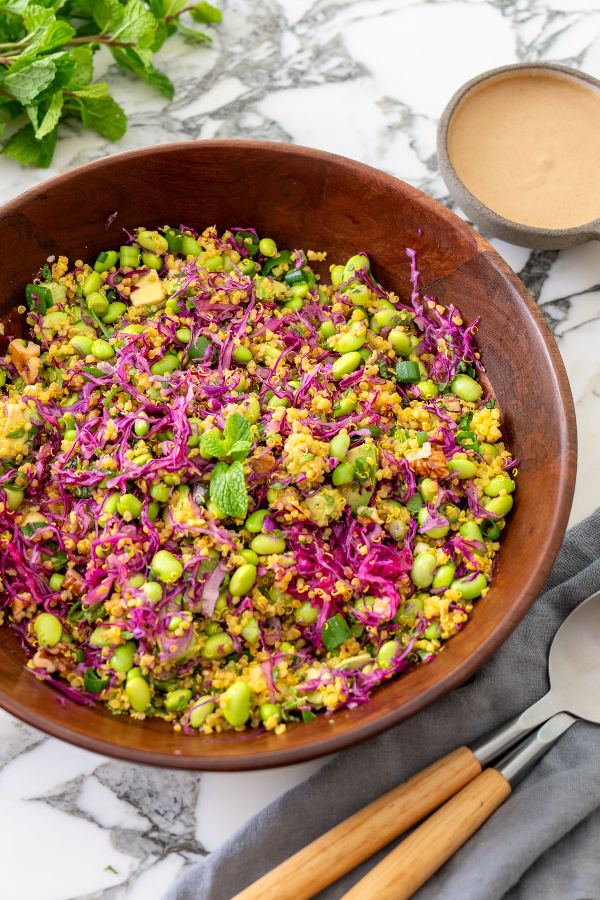 Turmeric quinoa and edamame salad with avocado, walnuts, and almond satay dressing