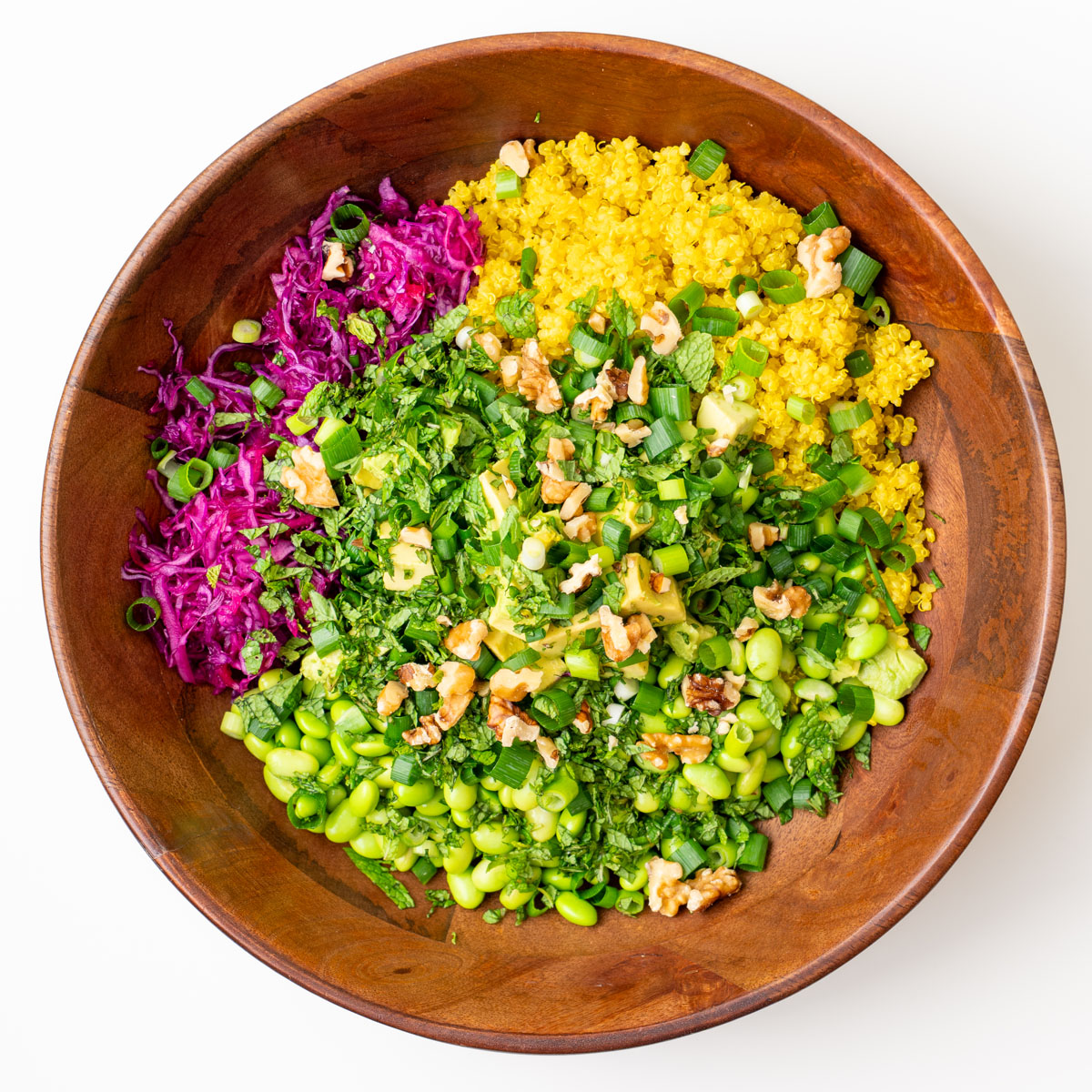 Iron-rich turmeric quinoa salad with edamame, red cabbage, scallions, and walnuts in a serving bowl
