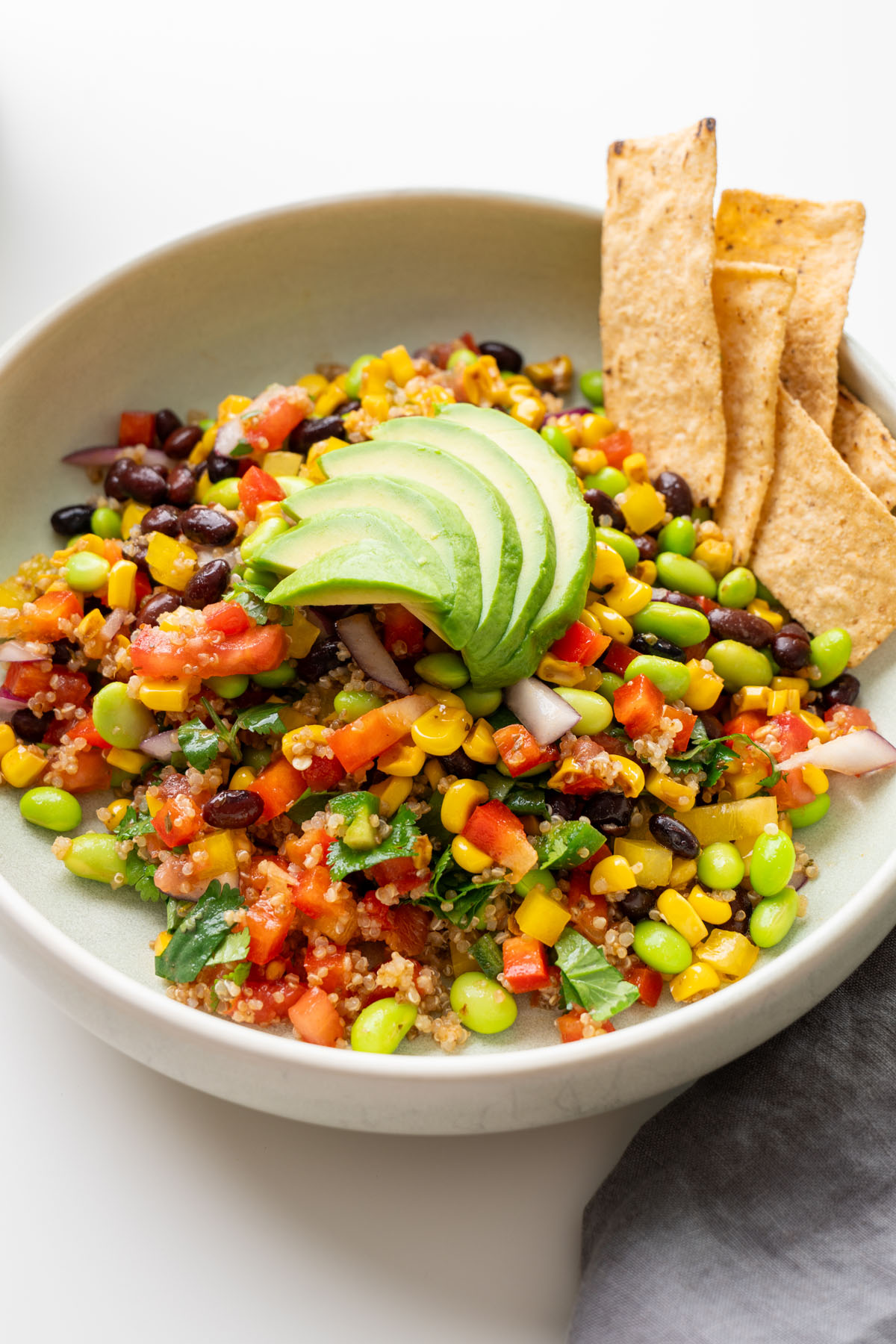 Fresh vegetables added to meal prep containers for Cowboy Caviar-inspired salad.