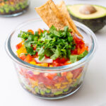 Close-up of Cowboy Caviar-inspired meal prep salad with cilantro, tortilla chips, and avocado.