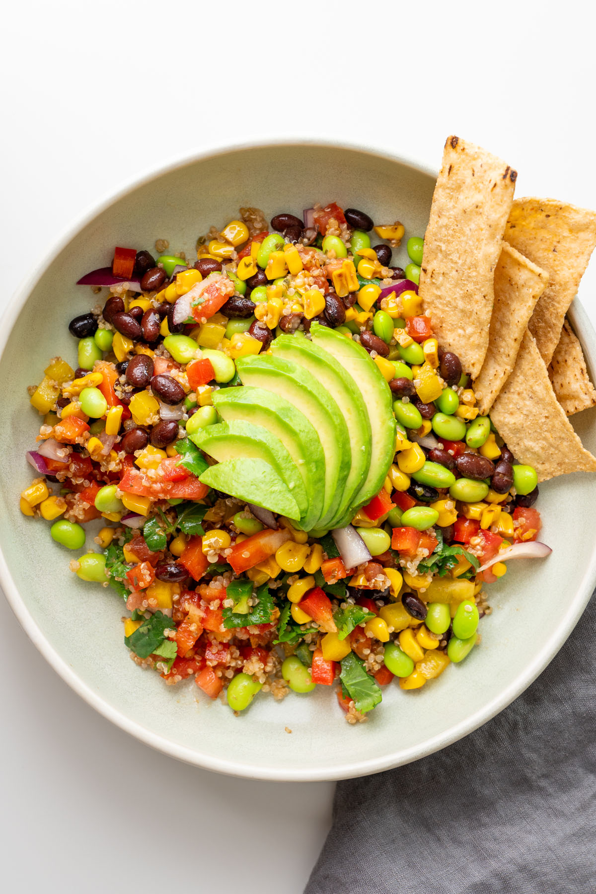 Quinoa layered into meal prep containers for Cowboy Caviar-inspired salad.