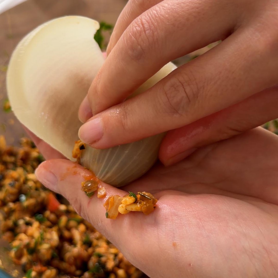 Sarah Cobacho rolling an onion layer around the filling.