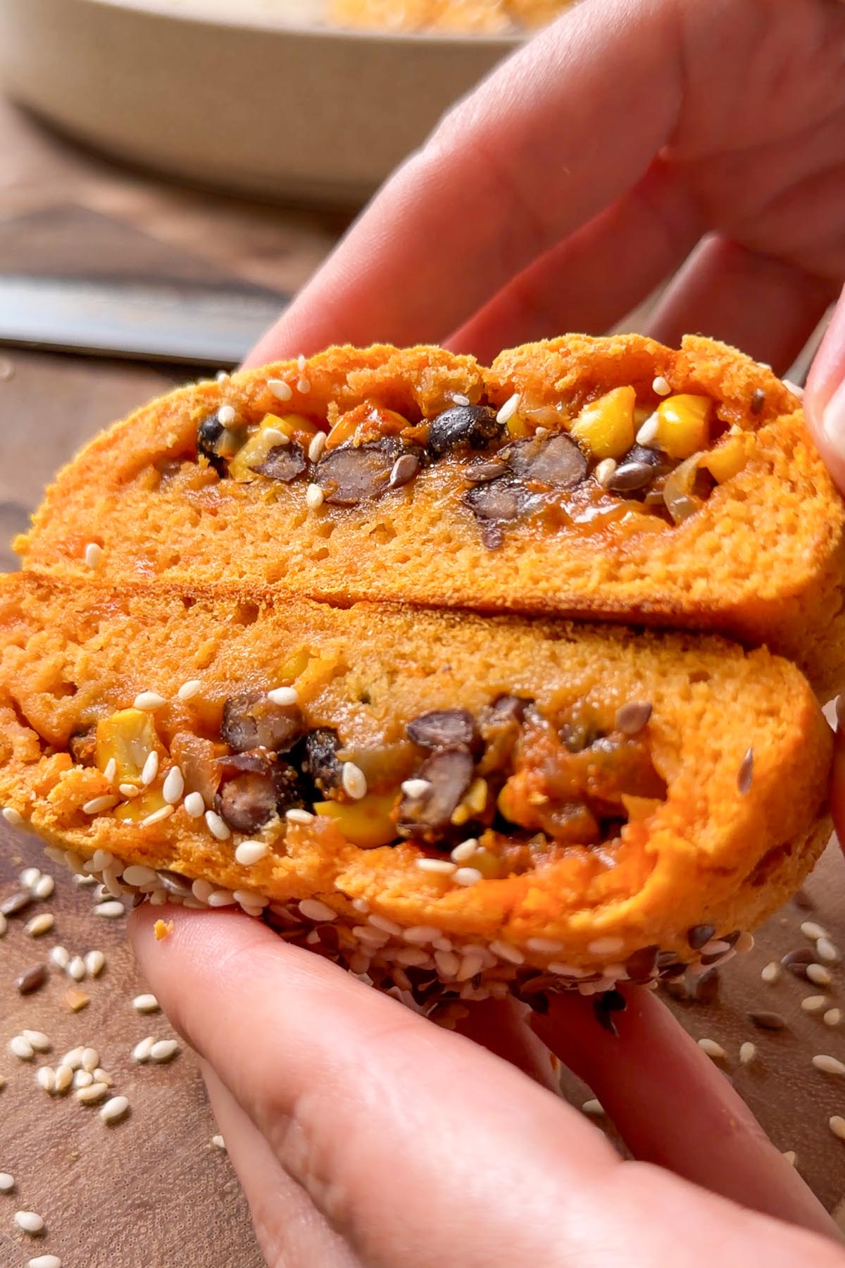 a sweet potato hot pocket split open in hand, showing the smoky black bean and corn filling.