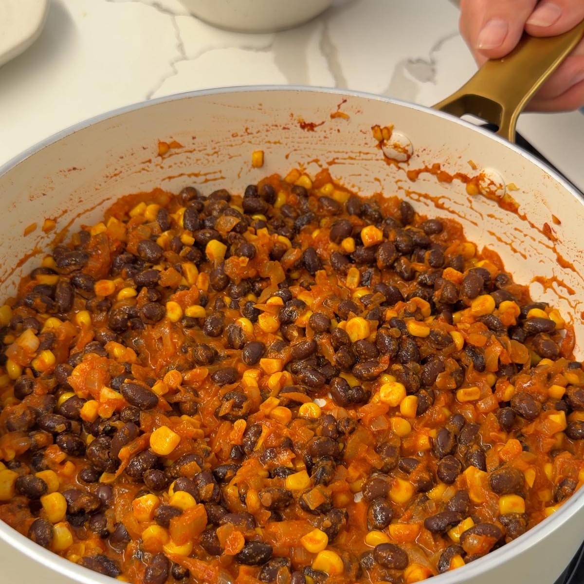 cooking onion, corn, spices and black beans in a pan for the filling.