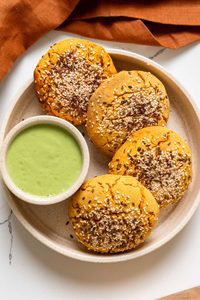 overhead view of Mexican sweet potato hot pockets on a plate with spicy cilantro sauce.