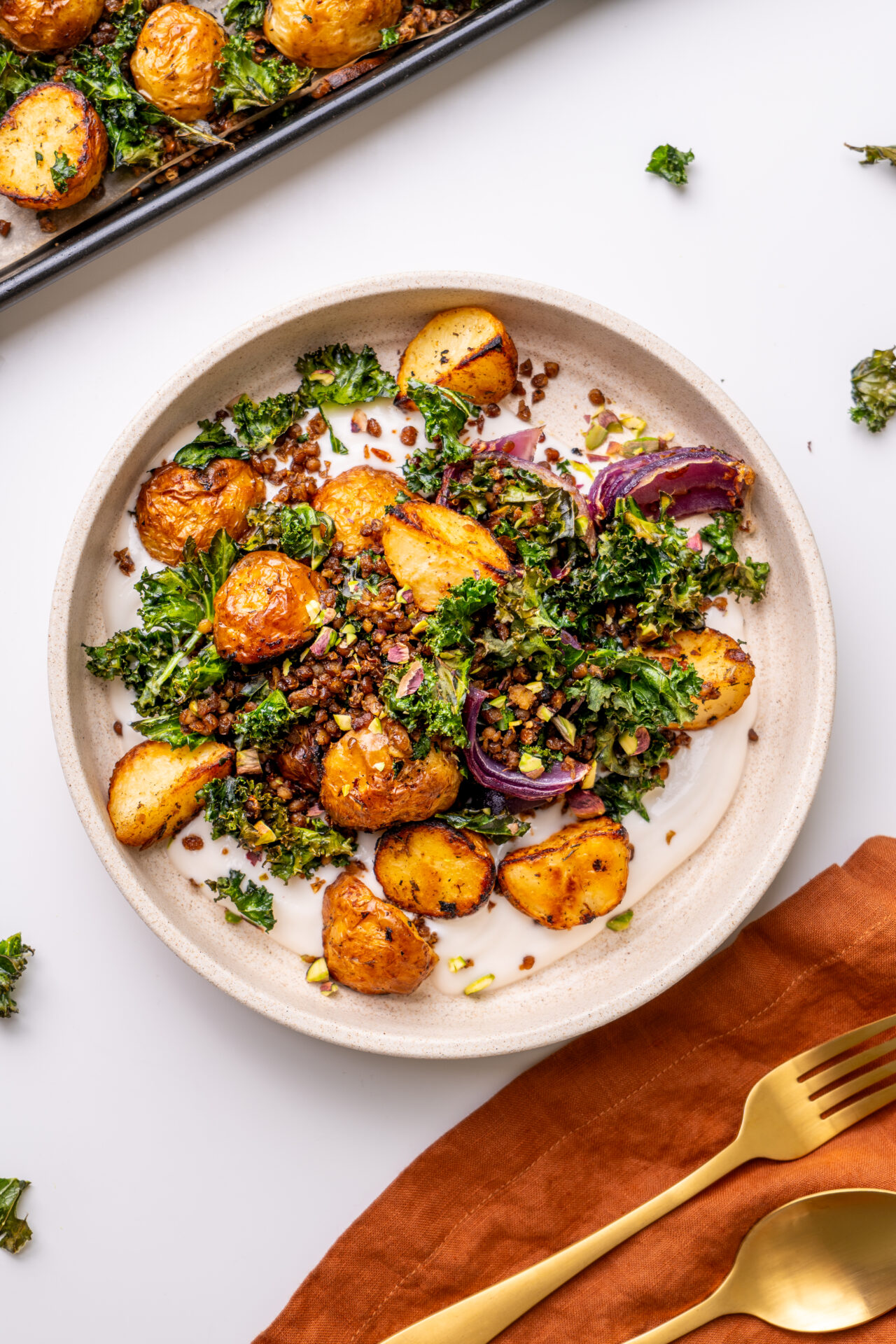 finished Sheet Pan Potato and Crispy Kale Bowl with creamy tahini yogurt drizzle.