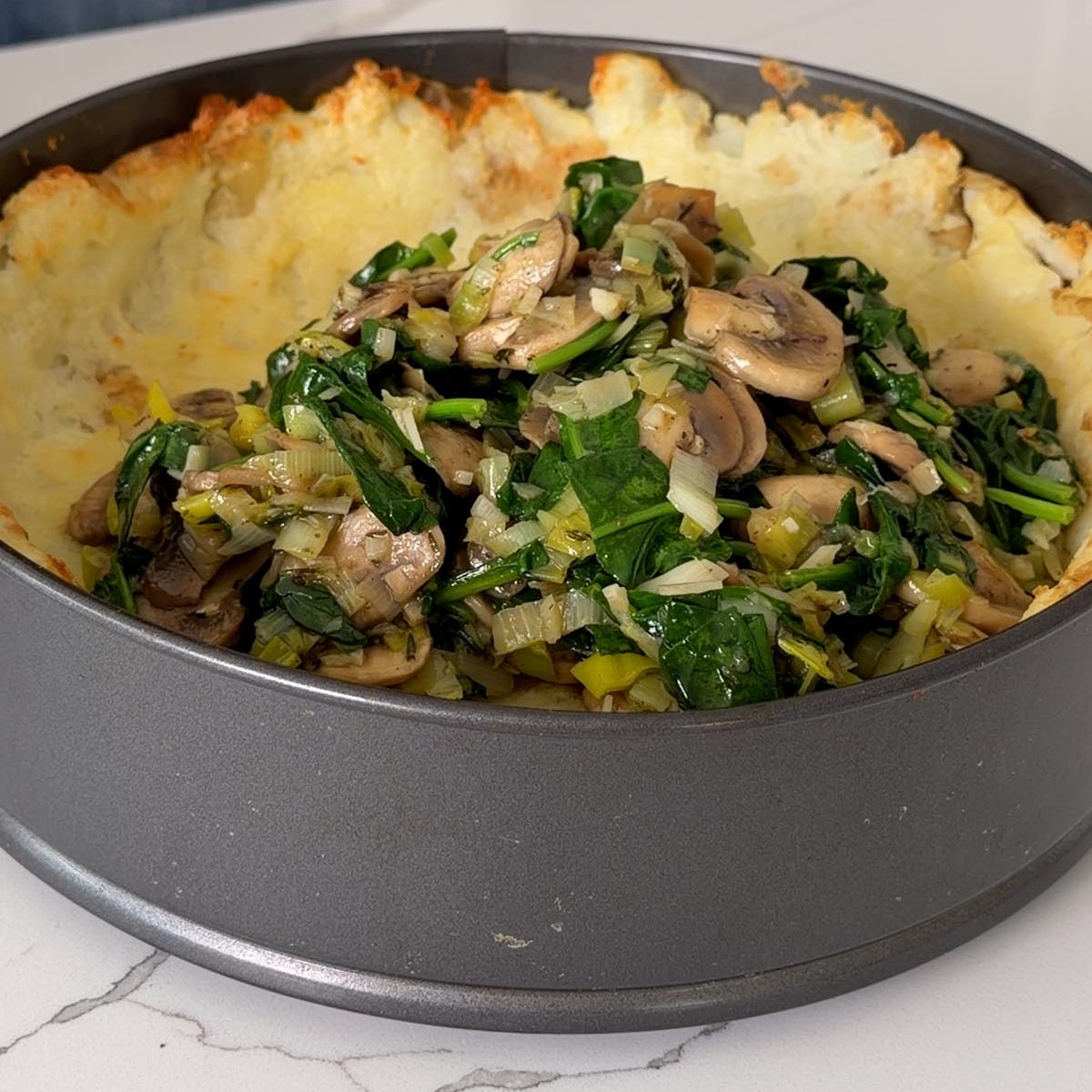 mushroom, leek and spinach filling spread over the baked potato crust.